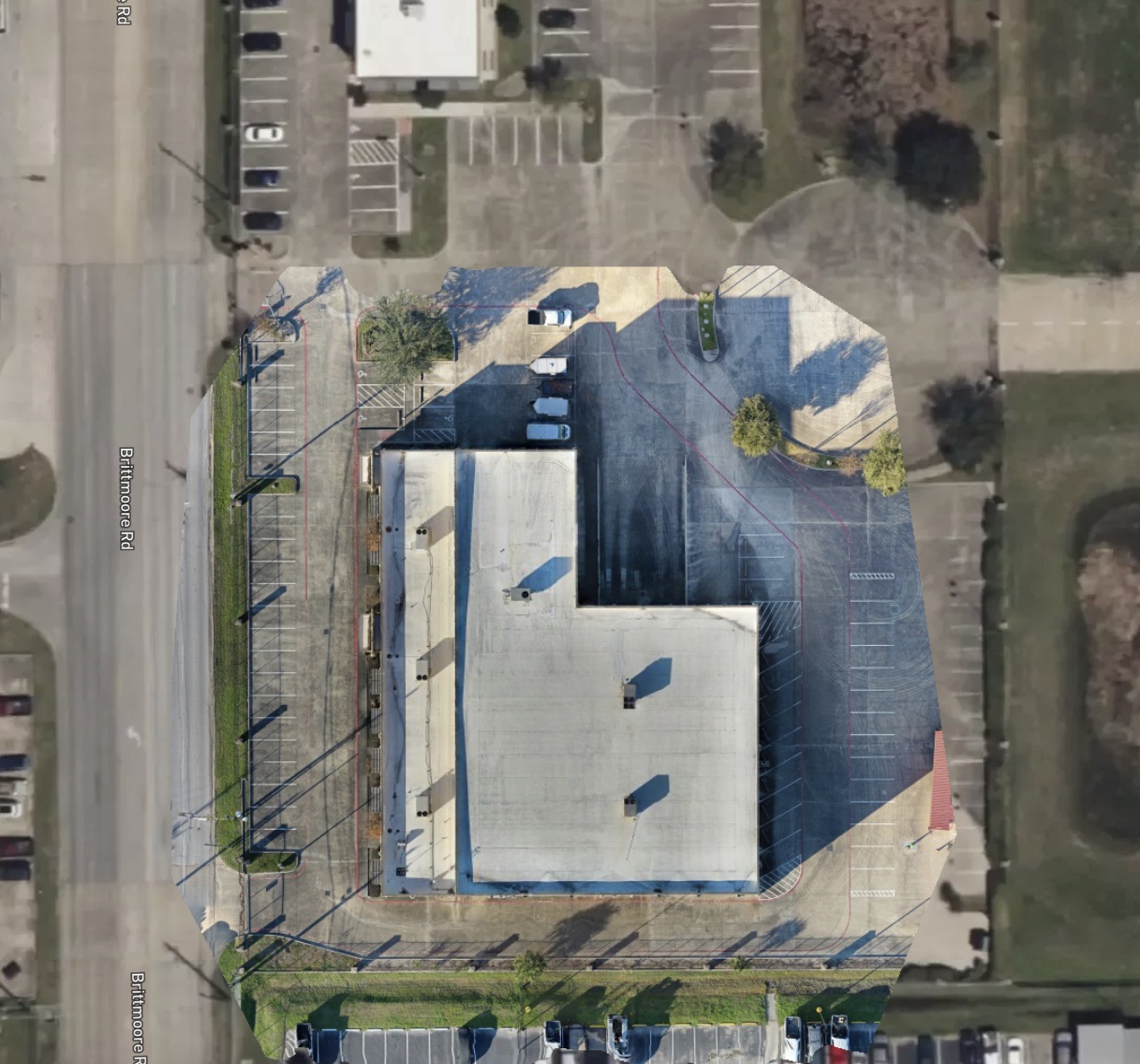 Orthomosaic of a commercial building and parking area adjacent to a road.