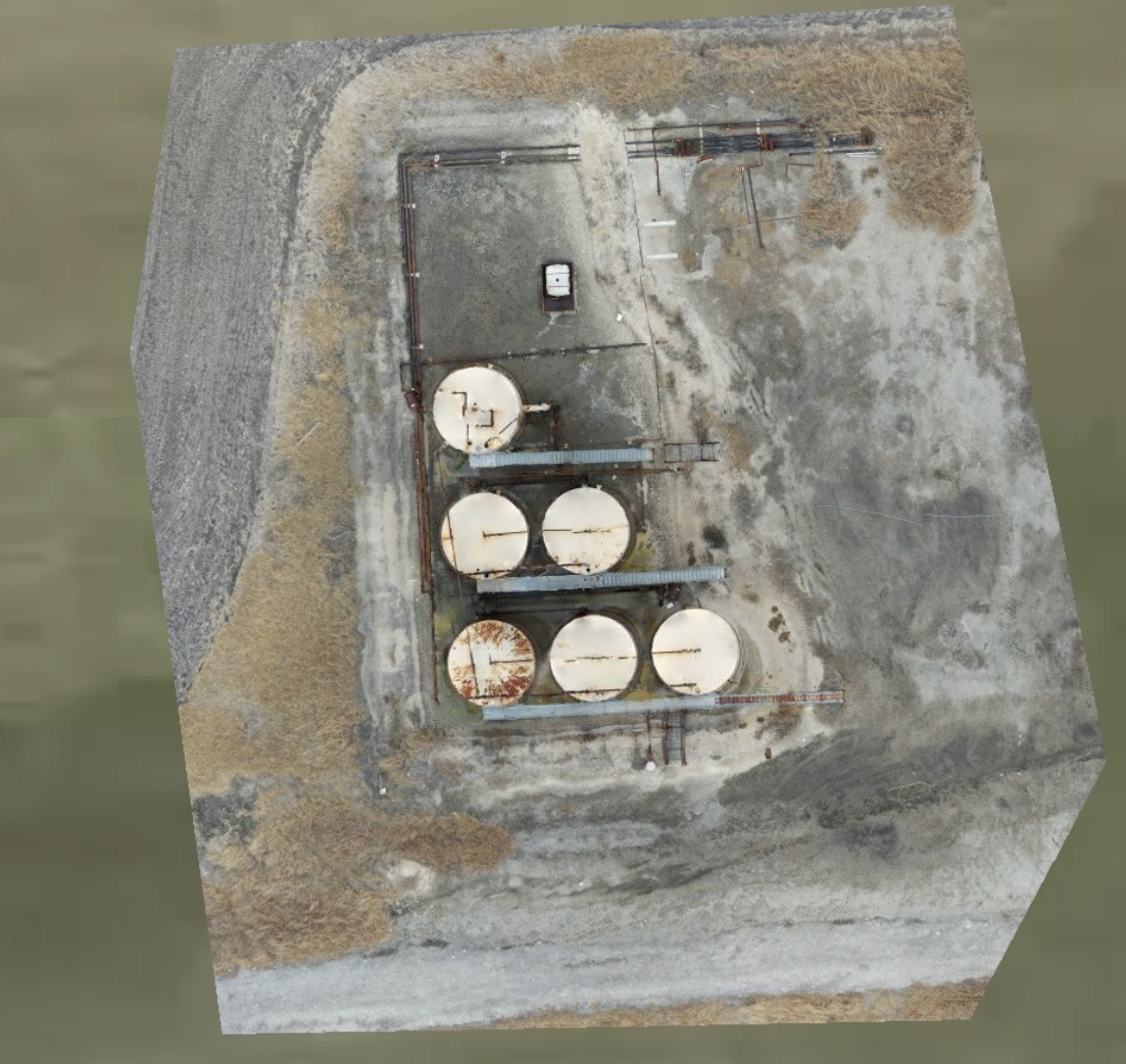 Orthomosaic of a tank farm with several circular storage tanks and access roads.