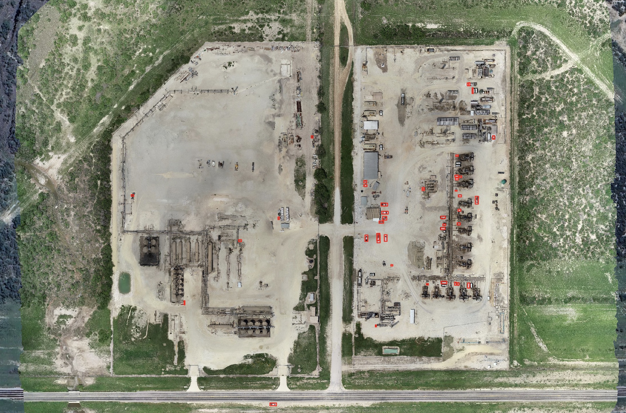 Large orthomosaic of an industrial yard with equipment rows and a central access road.