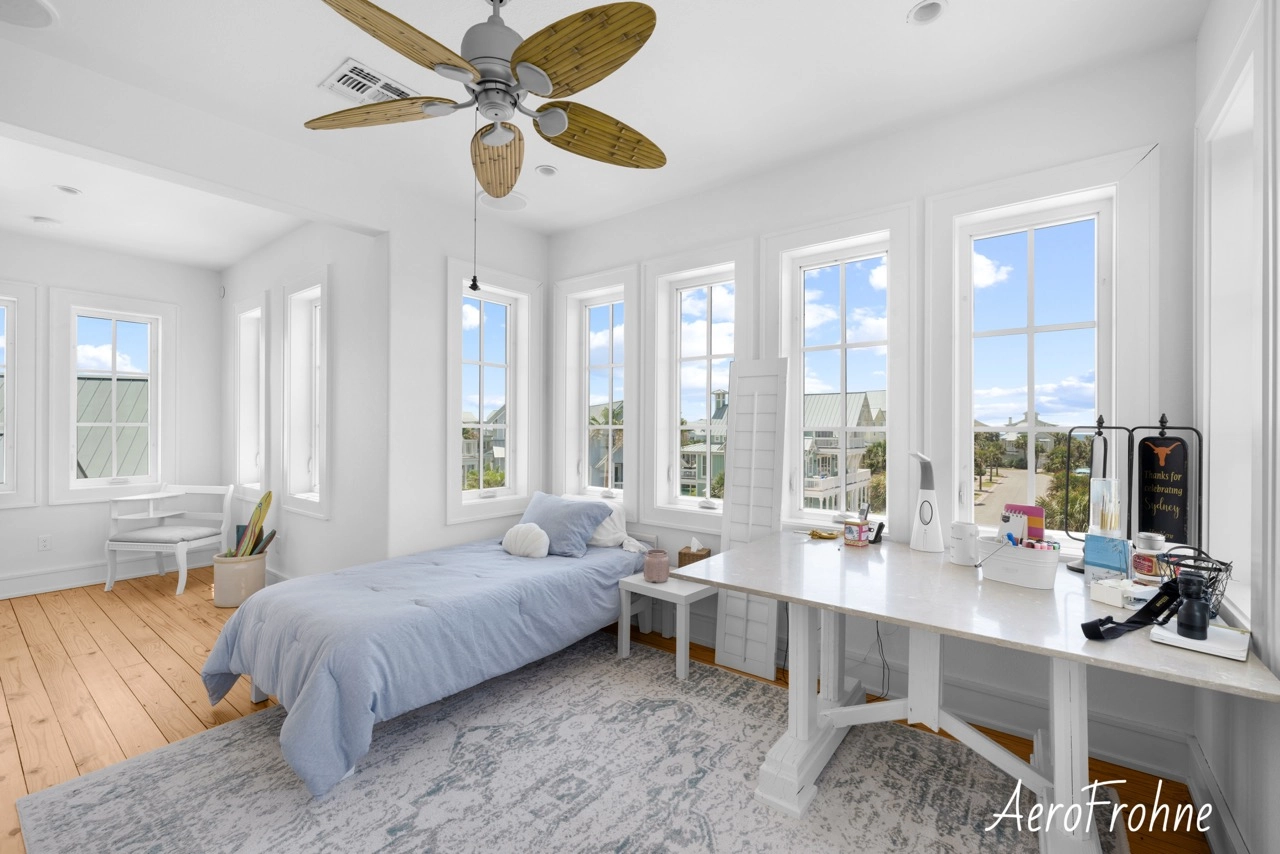 Bedroom with large windows, bed, and built-in desk