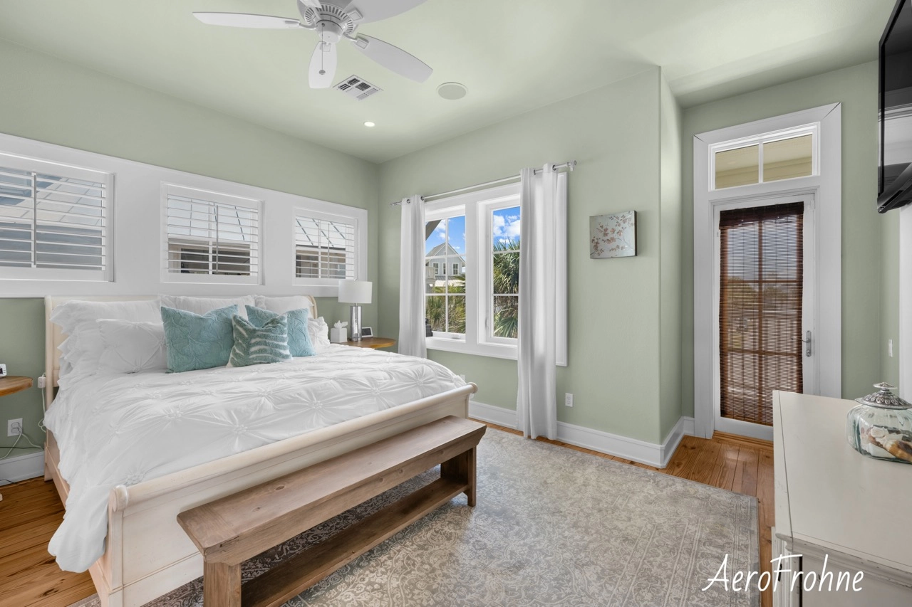 Bedroom with balcony door, stairway, and soft green walls