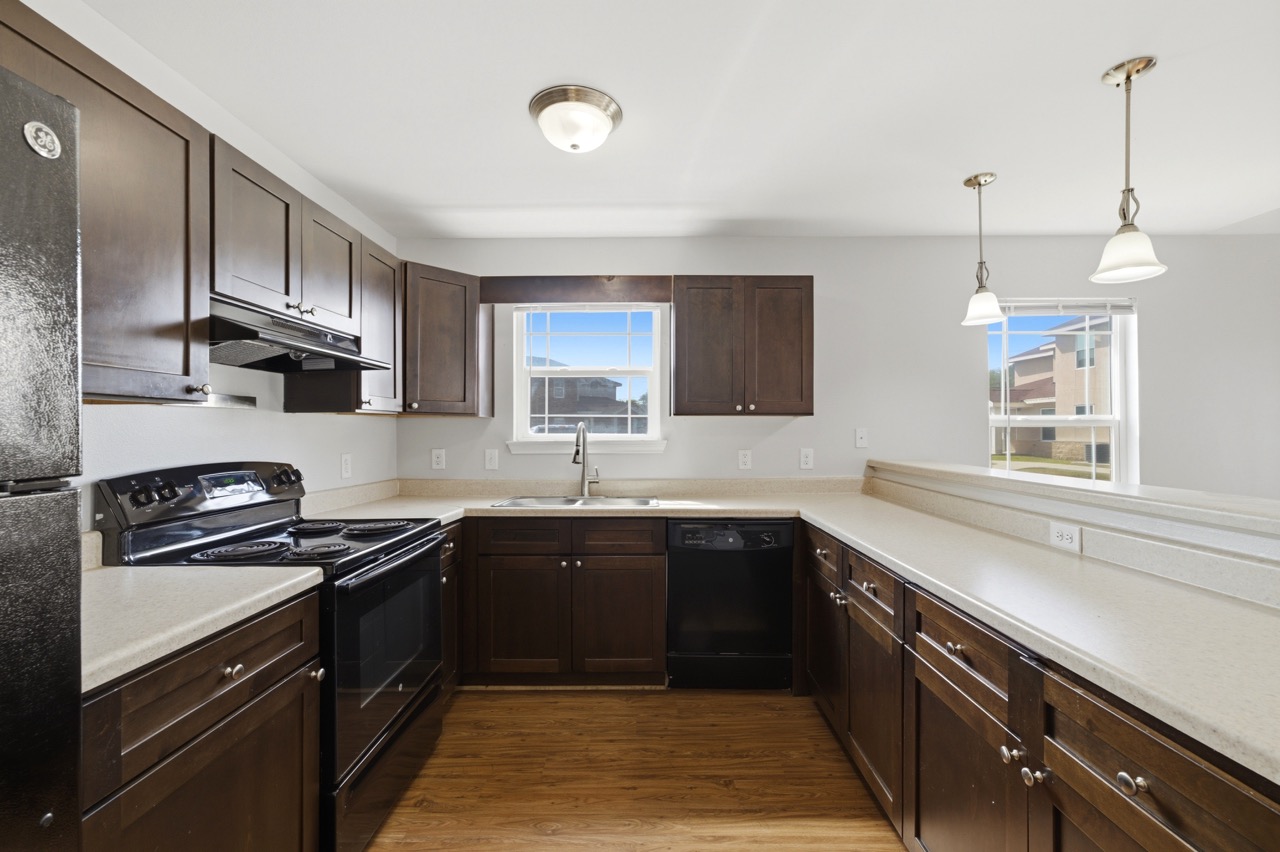 L-shaped kitchen interior with dark cabinetry and black appliances, Portland, Texas