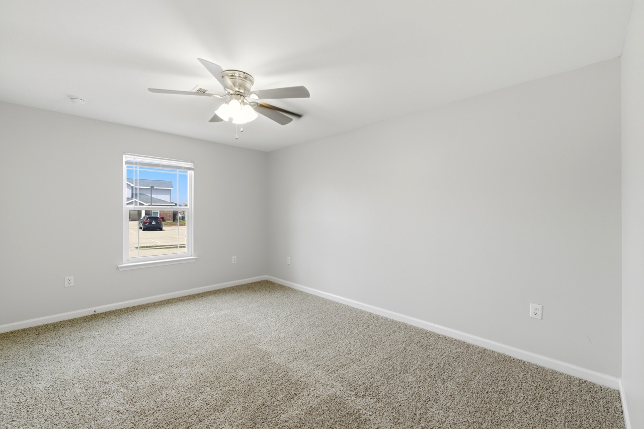 Interior view of a spacious empty bedroom or living room with grey walls and carpet, Portland, Texas