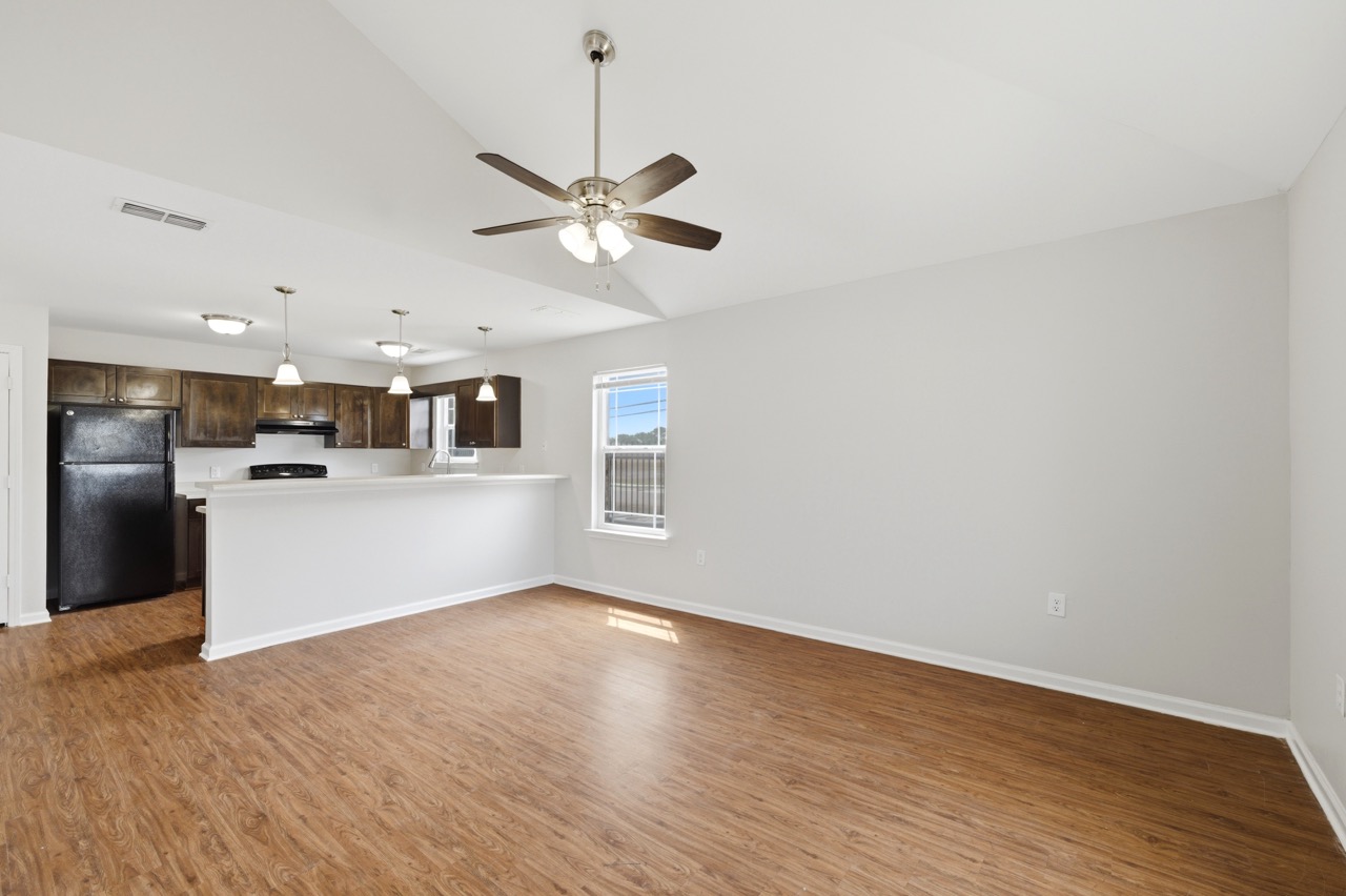 Expansive empty living area interior showcasing wood-look flooring, neutral walls, and high ceiling, Portland, Texas