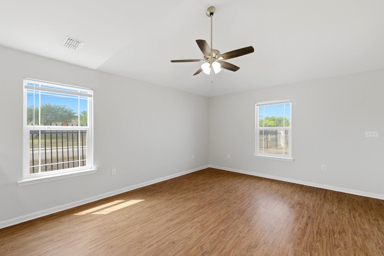 Interior perspective of an empty living room highlighting multiple windows, flooring, and neutral walls, Portland, Texas