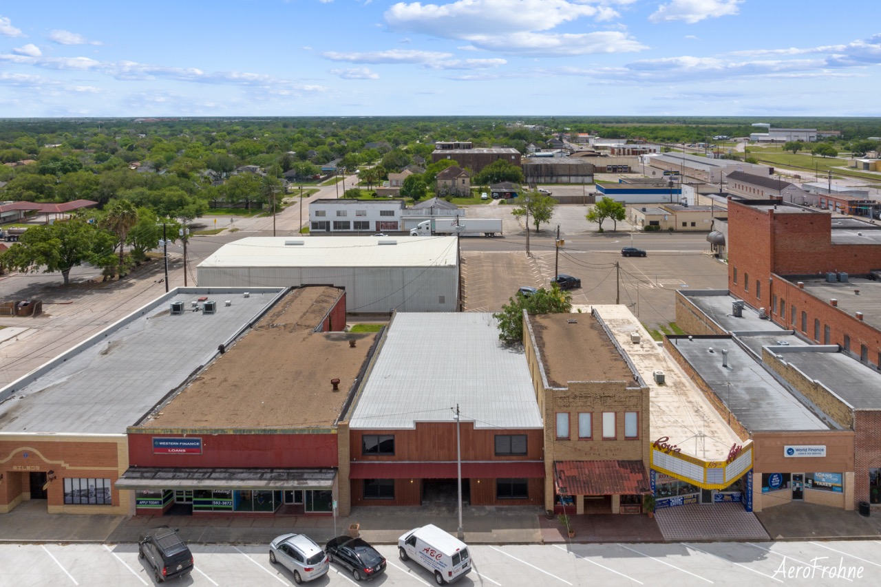 Aerial drone view of historic downtown Kingsville with flat-roofed commercial buildings and city streets.