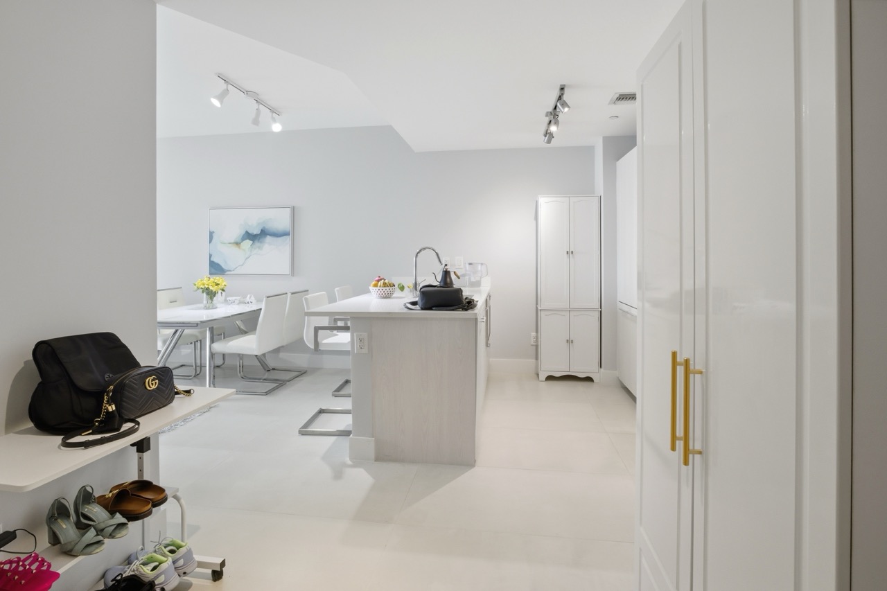 Entryway view leading into the kitchen with white island.