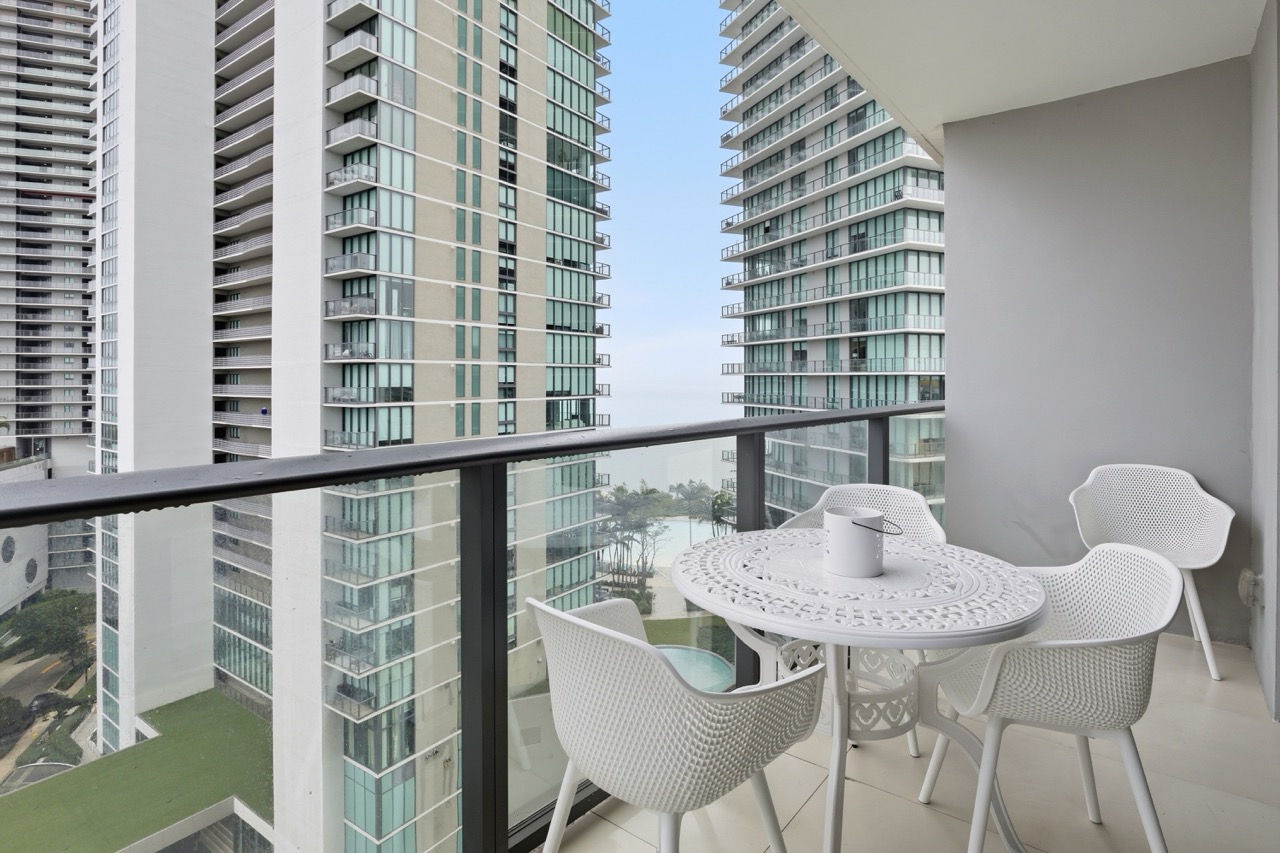 Balcony with bistro set overlooking Miami high-rises and bay.