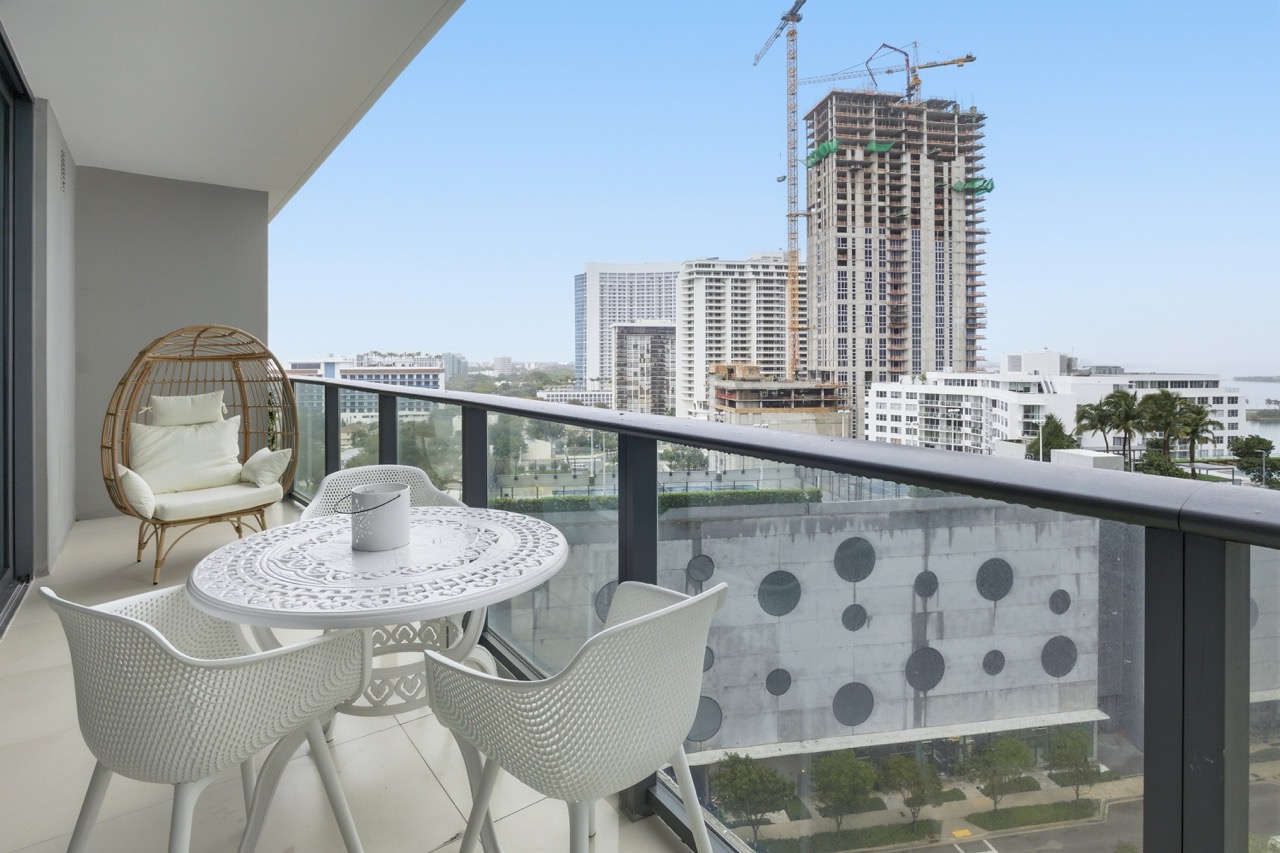 Spacious balcony with egg chair and city construction views.