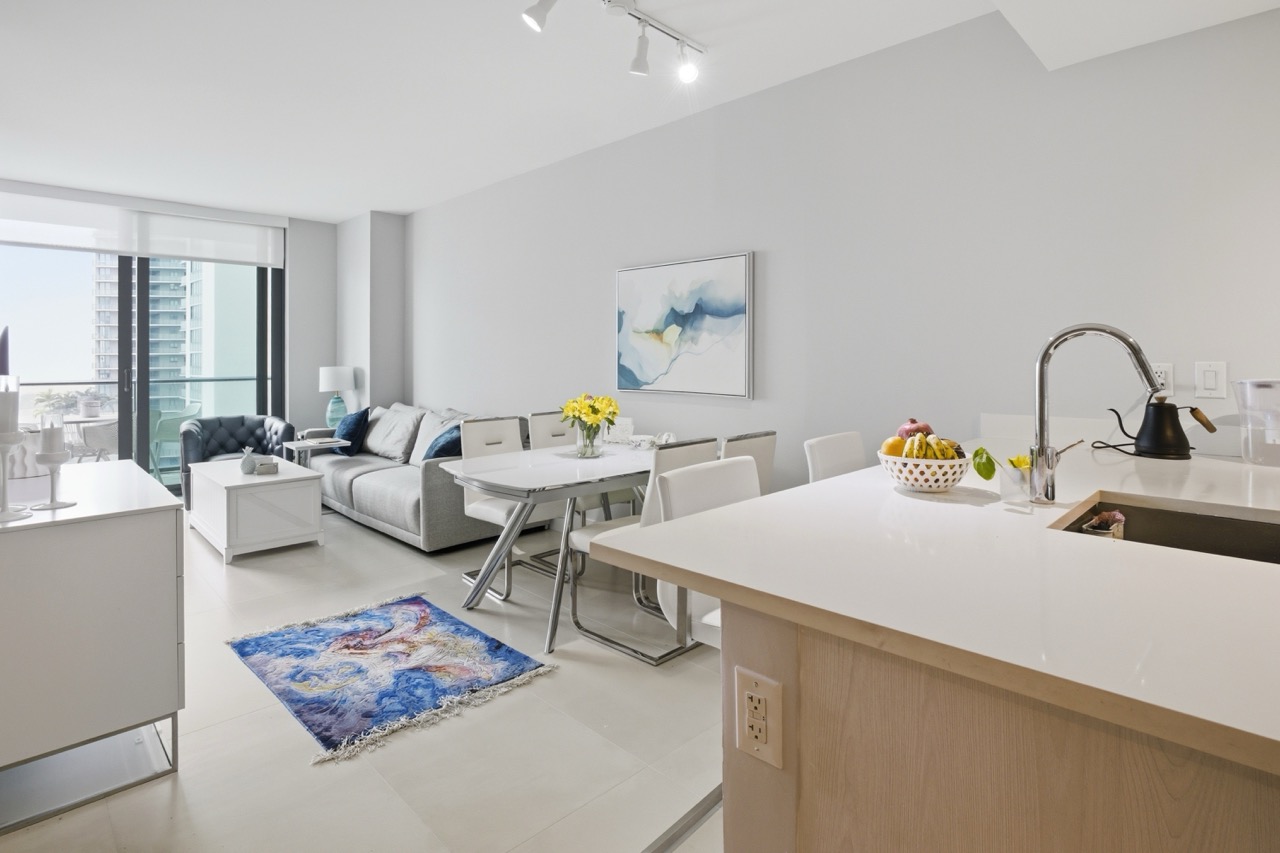 Wide view of the living and dining area filled with natural light.