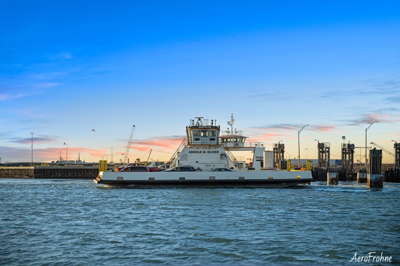 A ferry boat crossing the water at sunset