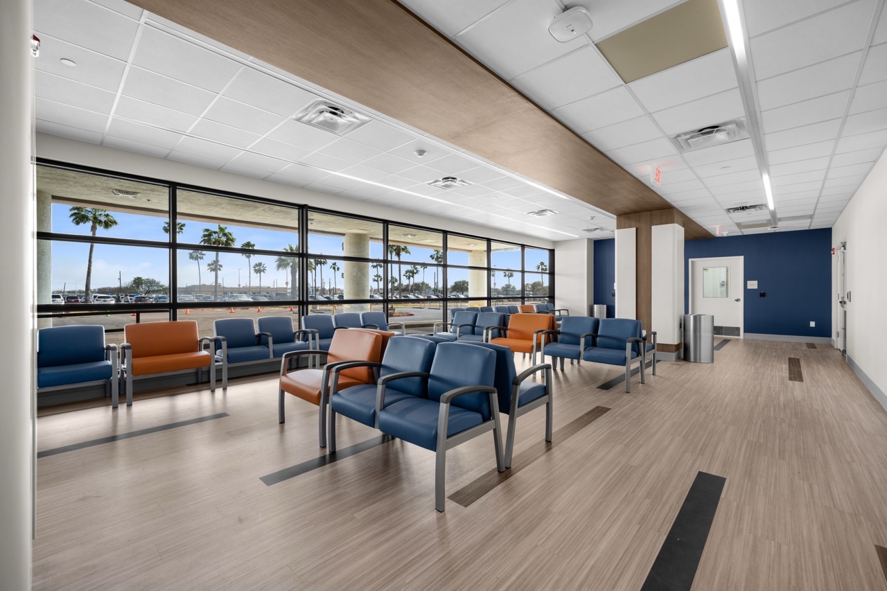 A modern medical waiting room with blue and orange chairs