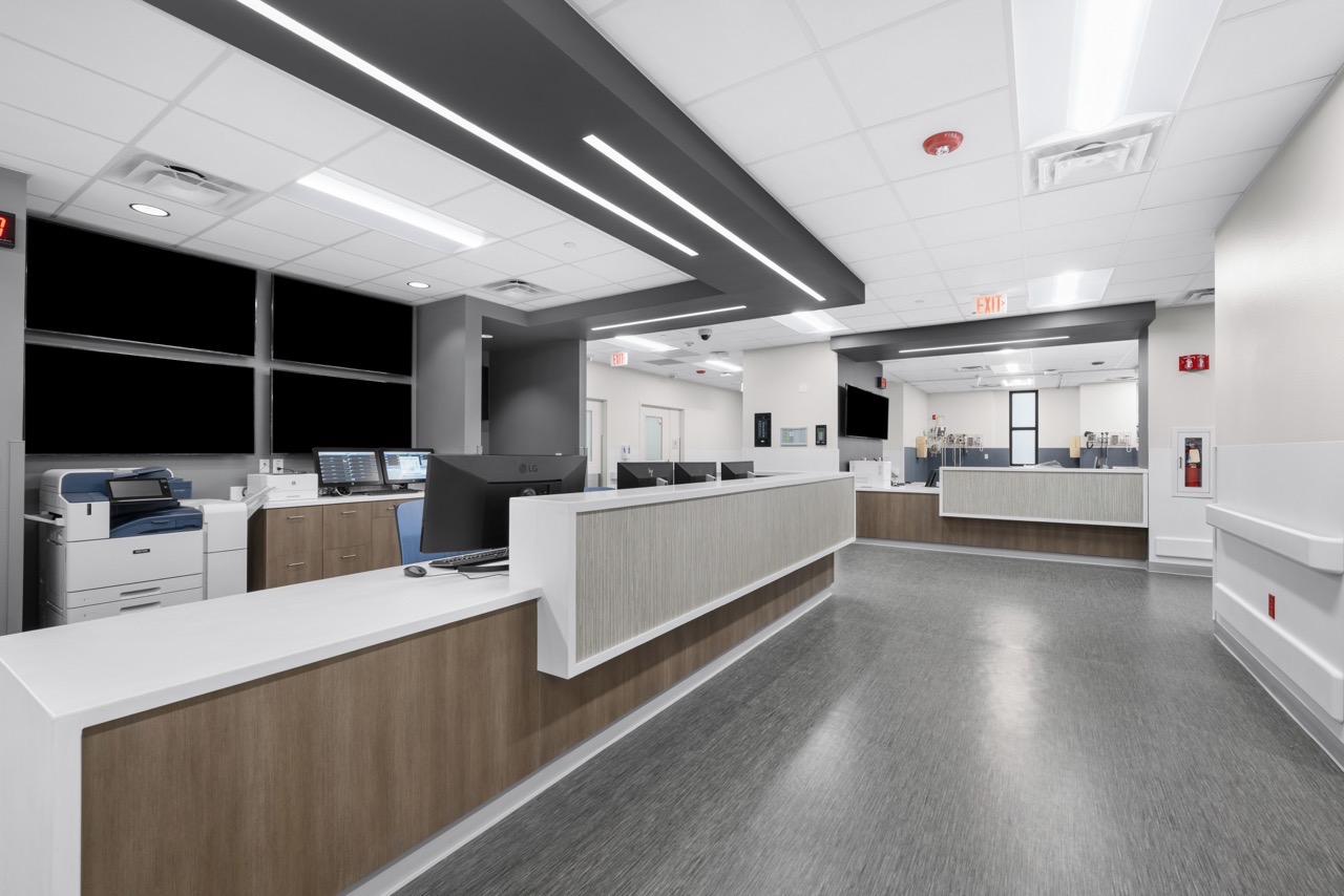 A large, modern nurse's station with white and wood accents